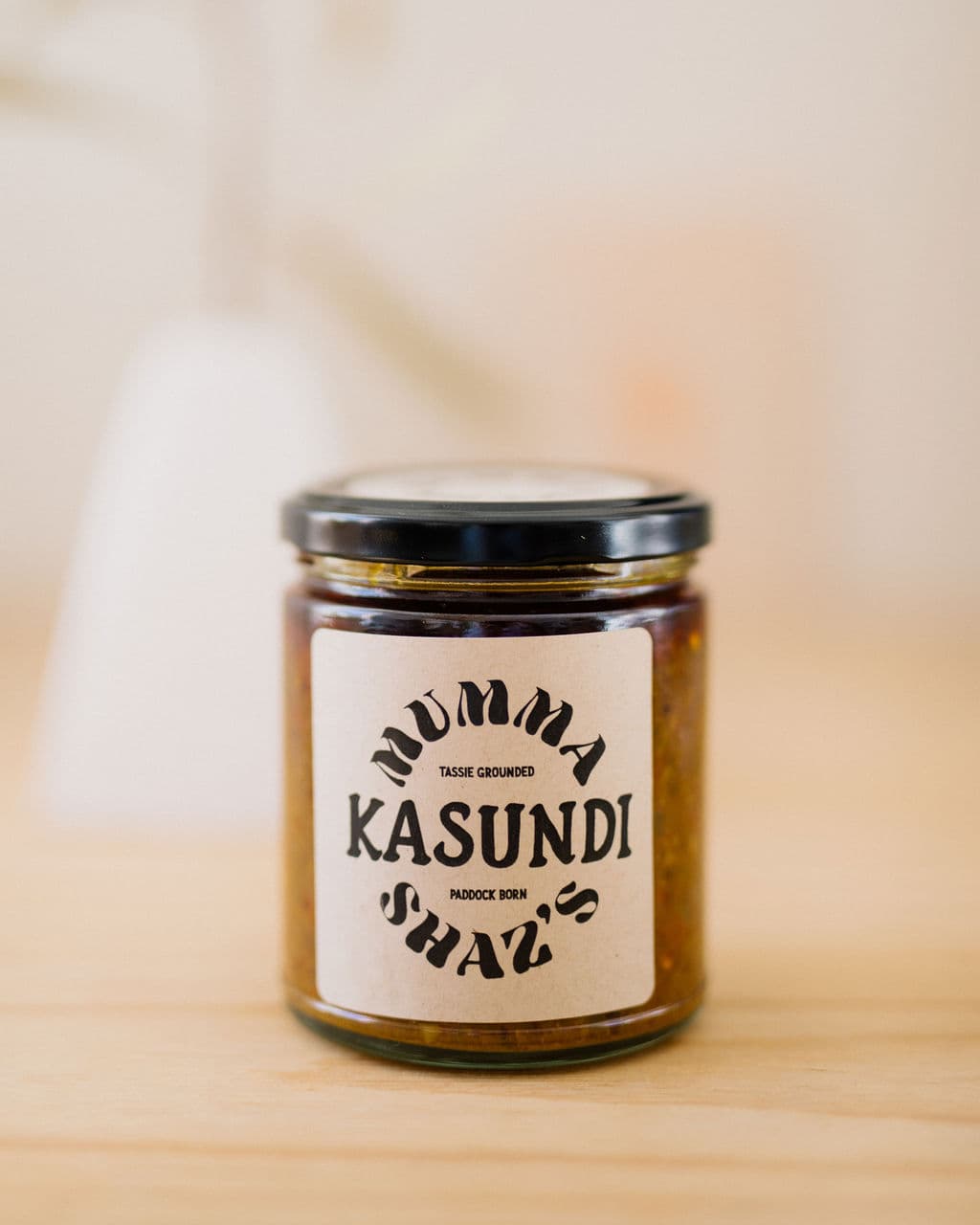 A jar of Mumma Shaz Kasundi on a Tasmanian timber table